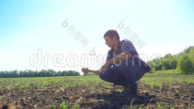 男人农民手里握着新鲜的土壤。 慢动作视频。 人的地面泥土保持泥土春天的象征